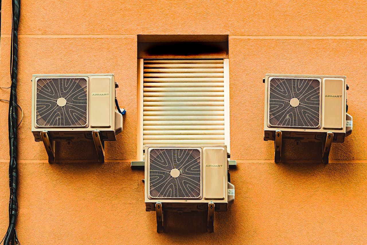 Exterior wall with three air conditioners, showcasing modern architectural elements.